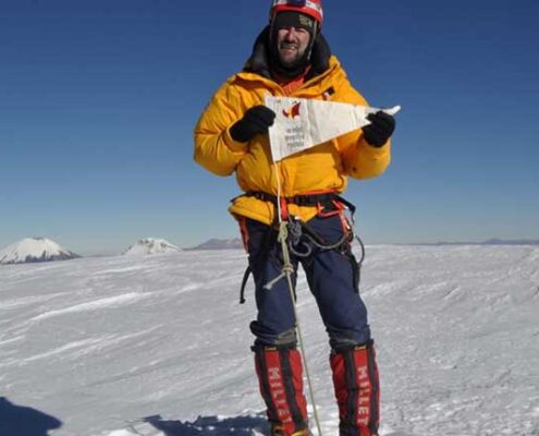 Juan García Arriaza, en la cima del Sajama posa orgulloso con el banderín de la SGE